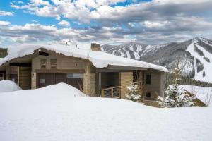 een huis bedekt met sneeuw met bergen op de achtergrond bij Mountain Home with Hot Tub, Near WP Resort! in Winter Park