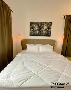 - un lit avec des draps et des oreillers blancs dans une chambre dans l'établissement View of Putrajaya, à Putrajaya