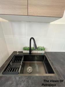 a kitchen sink with a faucet and two plants at View of Putrajaya in Putrajaya