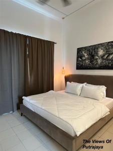 a bedroom with a large bed with white sheets at View of Putrajaya in Putrajaya