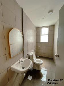 La salle de bains est pourvue d'un lavabo, de toilettes et d'un miroir. dans l'établissement View of Putrajaya, à Putrajaya