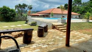 un patio trasero con piscina y una casa en Chácara dos Ypes, en Bueno Brandão