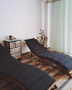 2 schwarze Ottomanen im Wohnzimmer in der Unterkunft Vita Natura with sauna and jacuzzi in Pihovec