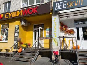 a yellow building with a sign on the front of it at Classic Apartment in Boryspil