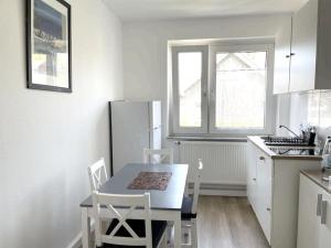 eine Küche mit einem Tisch und Stühlen sowie einem Kühlschrank in der Unterkunft Düsseldorf Messe and Airport, 2-bedroom Apartment with Kitchen and Garden in Am Sittardsberg