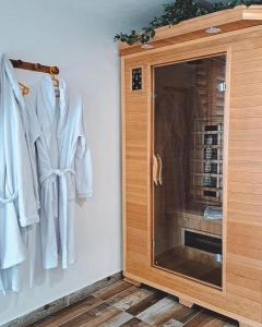 ein Schrank mit weißen Bademänteln an der Wand in der Unterkunft Vita Natura with sauna and jacuzzi in Pihovec