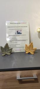 two sculptures of leaves on a table with a paper at Apartament Pod Klonem in Bartoszyce