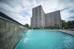 a large swimming pool in front of a tall building at Furnished 2br Apartment With Pool And Gym I Ave in Philadelphia
