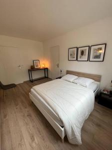 een slaapkamer met een groot wit bed in een kamer bij Dépendance campagne Rouennaise in Belbeuf