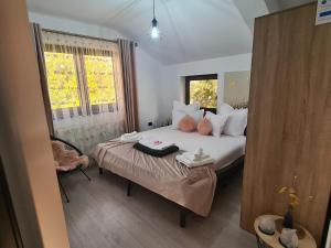 a bedroom with a bed and a window at PIATRA ROSIE Pensiune Agroturistică in Niculiţel +72 photos