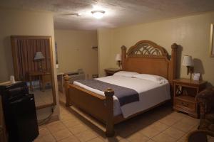 a bedroom with a large bed with a wooden headboard at La Hacienda Hotel in Laredo