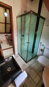 La salle de bains est pourvue d'une douche en verre et d'un lavabo. dans l'établissement Das SteinHaus, à Extrema