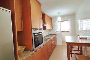 a kitchen with wooden cabinets and a stove top oven at Apartamento en Birdie Club in San Roque