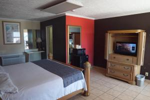 a bedroom with a bed and a television in it at La Hacienda Hotel in Laredo