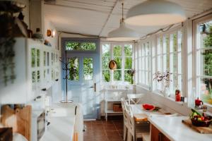 cocina con ventanas, mesa y sillas en Country house Harmonia, en Modra