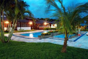 una palmera frente a una casa con piscina en Bartholo Plaza Hotel Santa Catarina, en Penha