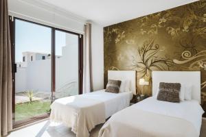 een hotelkamer met 2 bedden en een raam bij Villa Faro in Playa Blanca