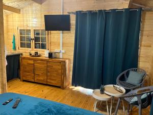 una camera con tenda blu e tavolo e sedie di Les Chalets de Marie & Steph 2 - Vue mer, Jacuzzi SPA privatif Sans vis à vis a Saint-Denis