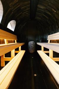 un túnel oscuro con bancos de madera y un barril en Premium Ferienhaus Das Farmhaus - Auf den Moselhöhen - Pool, Sauna, Kino, Garten, en Lieg