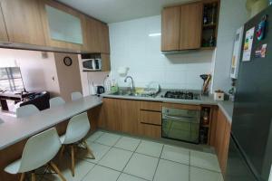 uma cozinha com armários de madeira e pisos em azulejo branco em Desconexión, tranquilidad y disfrute en El Tabo em El Tabo