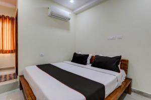 a bedroom with a large bed with black pillows at Flagship Skd Hotel And Banquet in Lucknow