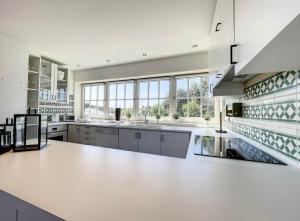 cocina grande con encimeras blancas y ventanas en Residence Dunes et Mer, en Koksijde