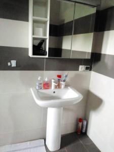 uma casa de banho com um lavatório branco e um espelho. em Villa magnifique avec piscine em Somone