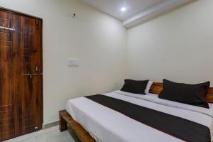 a bedroom with a bed and a wooden door at Flagship Skd Hotel And Banquet in Lucknow