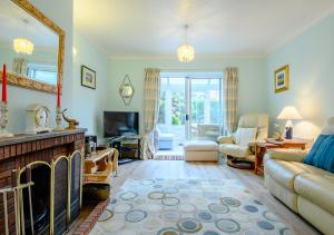 a living room with a fireplace and a tv at Rainbow Cottage in Thorpeness