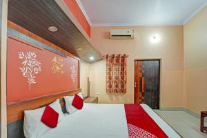 a bedroom with a large bed and a red wall at OYO Flagship Darsh Residency in Dhanbād