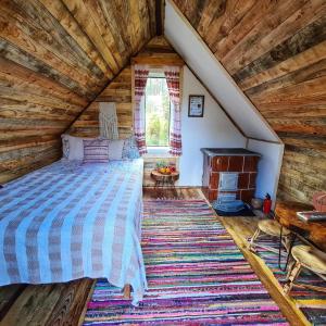 a bedroom in a log cabin with a bed and a fireplace at Friendship Cabin (Friendship Land) in Şelari