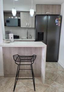 a kitchen with a counter and a black refrigerator at Modern High-Rise 2/2 Apartment with City View. in Sabaneta