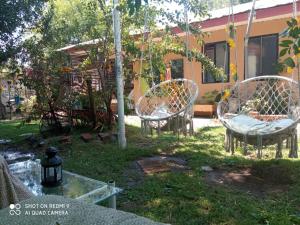 2 chaises assises dans la cour d'une maison dans l'établissement Familiar Hostal, à Chillán