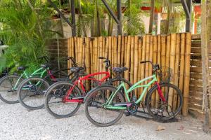 un grupo de bicicletas estacionadas junto a una valla de madera en Living Hotel, en Nosara