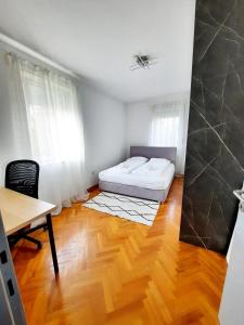 1 dormitorio con cama, escritorio y mesa en Franko's Cozy Apartment with garage, en Zagreb
