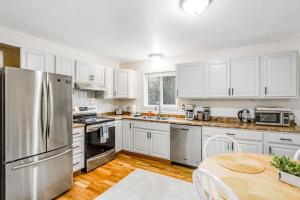 a kitchen with white cabinets and a stainless steel refrigerator at Bear Necessities in Eagle River