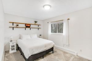 a white bedroom with a bed and a window at Bear Necessities in Eagle River