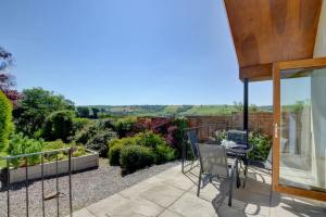 a patio with a table and chairs in a garden at 2 bed garden cottage nestled on the edge of Exmoor in Bishops Nympton