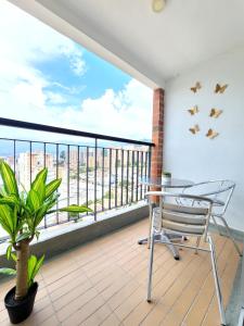 a balcony with a chair and a view of the water at Modern High-Rise 2/2 Apartment with City View. in Sabaneta