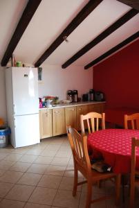 a kitchen with a table and a white refrigerator at Hostel Ociski Raj in Kozina