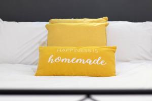 Una almohada con las palabras "la felicidad es casera en una cama" en 'The Lodge' Bedworth, en Bedworth