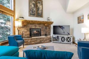 sala de estar con chimenea y TV en Adventure awaits in cozy retreat between Vail and Beaver Creek, en Vail