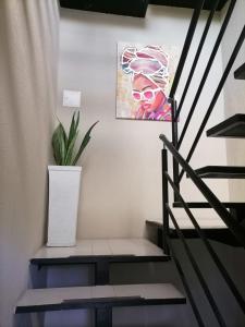 a stairway with a painting and a potted plant at Edif HA in Cartagena de Indias