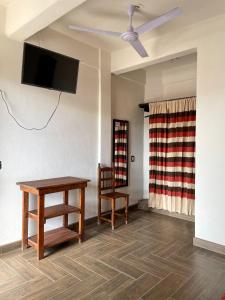 uma sala de estar com uma mesa, uma televisão e uma cadeira em Hotel Yubazuu em San Pablo Villa de Mitla
