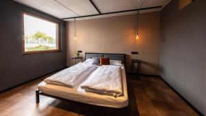a bedroom with a large bed with a window at Stadthaus Neckarsulm serviced apartments - Stadthaus Heiner in Neckarsulm