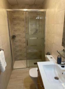 uma casa de banho com um chuveiro, um WC e um lavatório. em Apartment Los Boliches Fuengirola Malaga Spain em Fuengirola
