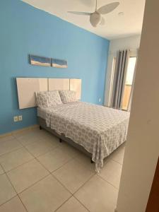 1 dormitorio con 1 cama en una habitación azul en Relaxe e curta num duplex completíssimo, en Lauro de Freitas