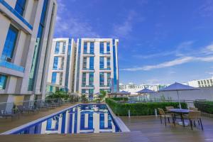 a hotel with a swimming pool in front of a building at Vista Park Hplus Long Stay in Brasília