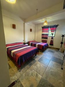 a bedroom with two beds and a window at Hotel Yubazuu in San Pablo Villa de Mitla