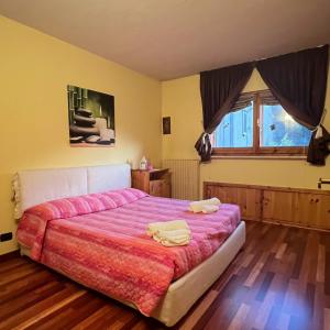 a bedroom with a large bed with a pink blanket at Brain Residence Laceno in Villaggio Laceno